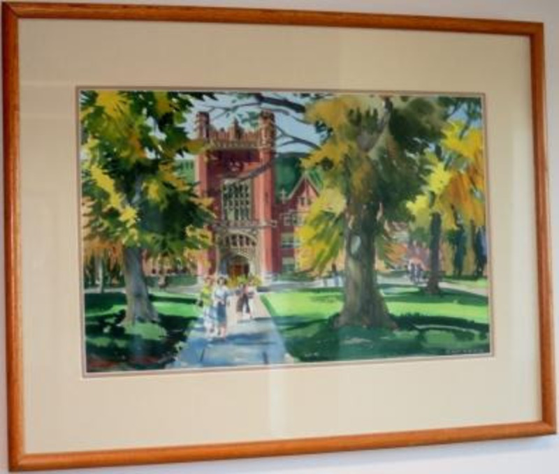 Watercolor painting depicting the U of I Admin building with trees and people walking on the pathway in front. It is displayed in a light wood frame.