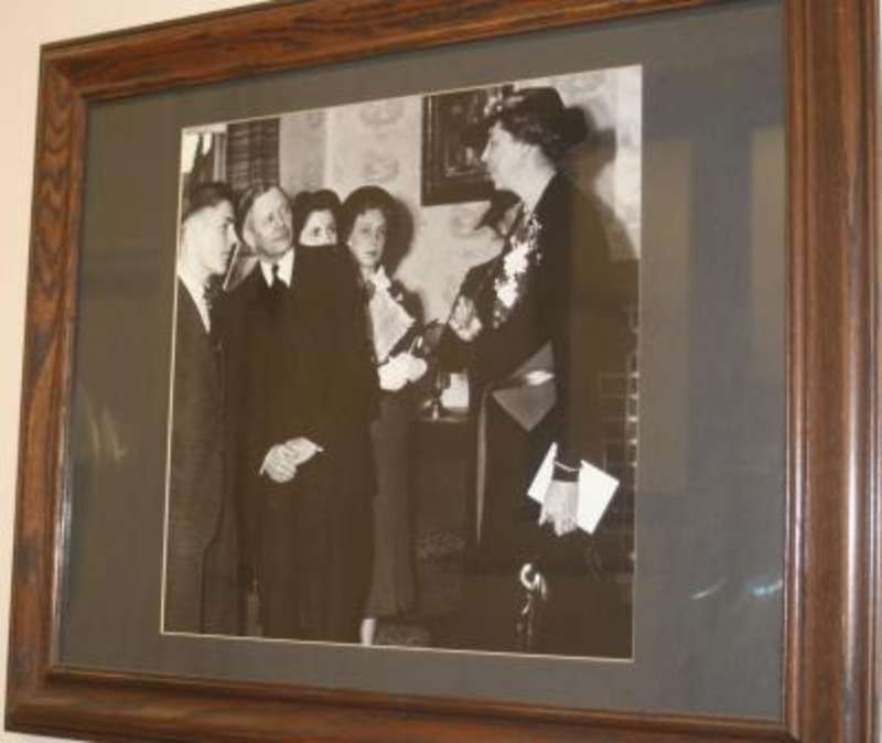 Black and white photograph of University of Idaho President Harrison Dale with Eleanor Roosevelt. There are two females in the background and a man with President Harrison. This piece is framed and displayed under glass.