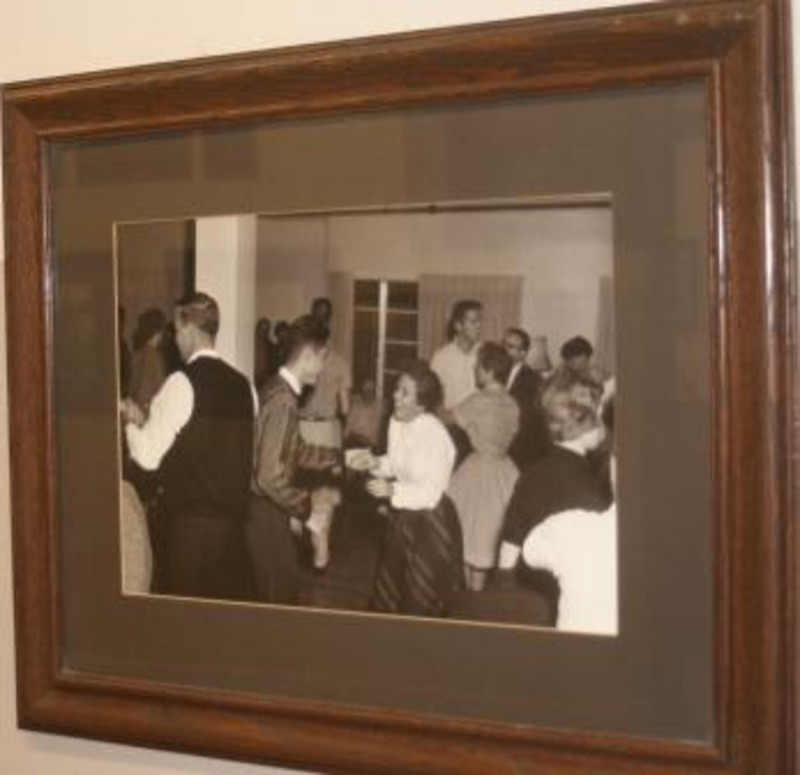 Black and white photograph of student dancing at the Nickle Hop. Displayed under glass in a wooden frame.
