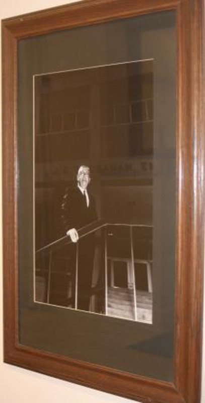 Black and white photograph of Jesse E. Buchanan, president of the University of Idaho 1946–1954. Displayed under glass in a wooden frame.