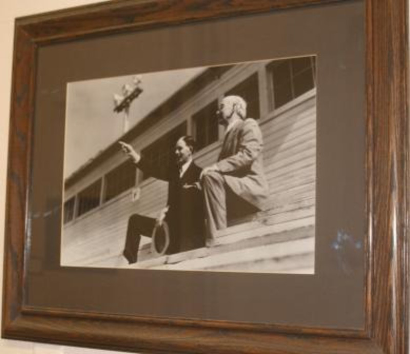 Black and white photograph of Mervin Neale and James MacLean, University of Idaho President 1900-1913, together on wooden stadium seating. Displayed under glass in a wooden frame.