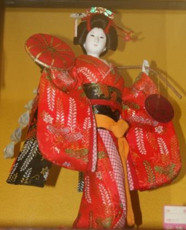 Japanese Oyama doll dressed in a red kimono with an ornate hair pin. Rough dimensions are 17.5"x12"x9.5"