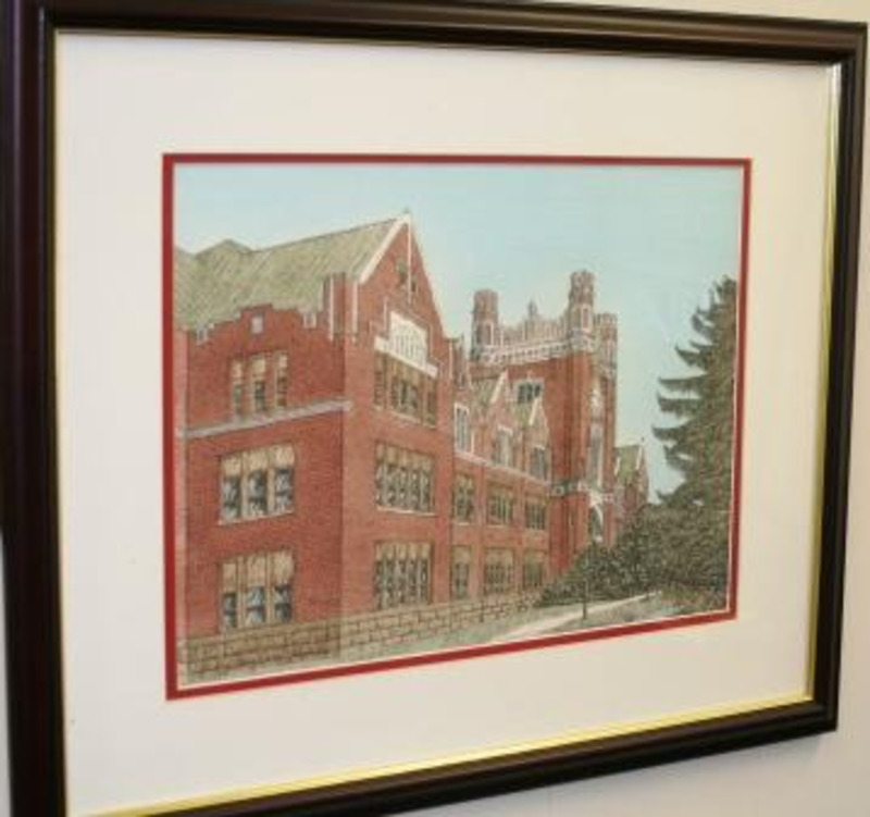 Painting showing the facade of the University of Idaho Administration building. Displayed using a red trimmed cream matte in a gilt dark wood frame.