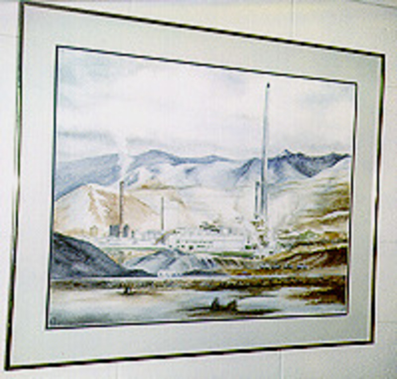Painting showing an industrial facility in a hilly landscape. Displayed using a dark blue trimmed grey matte in a silver metal frame.