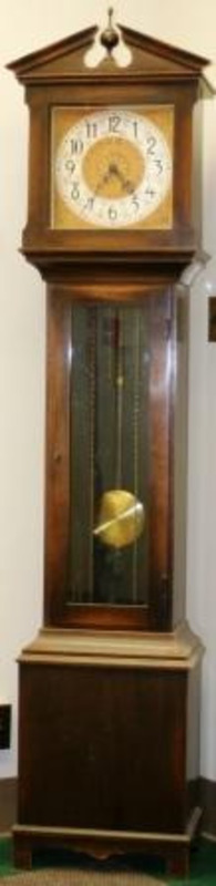 Grandfather clock made from wood, glass, and metal.