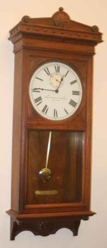 Wall mounted pendulum clock made from glass, metal and wood. The clock has been refinished using new clock works but the original clock face.