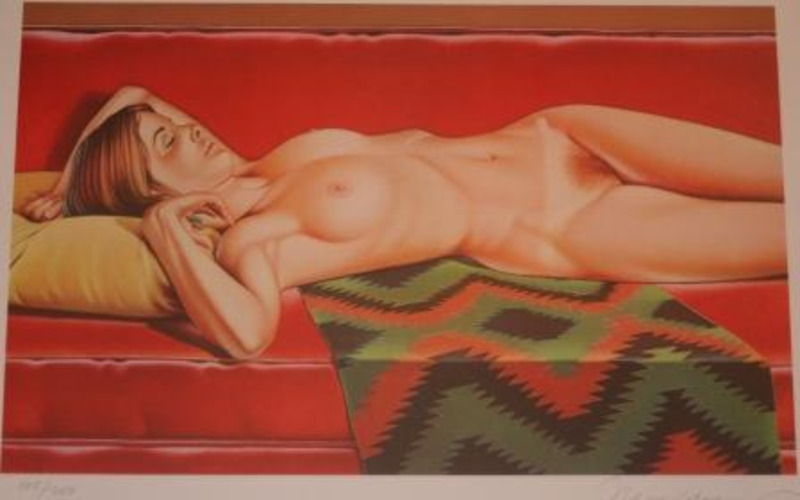 Collotype print showing a nude woman reclining on a Navajo pattern rug on a red couch. Stored in archival portfolio.