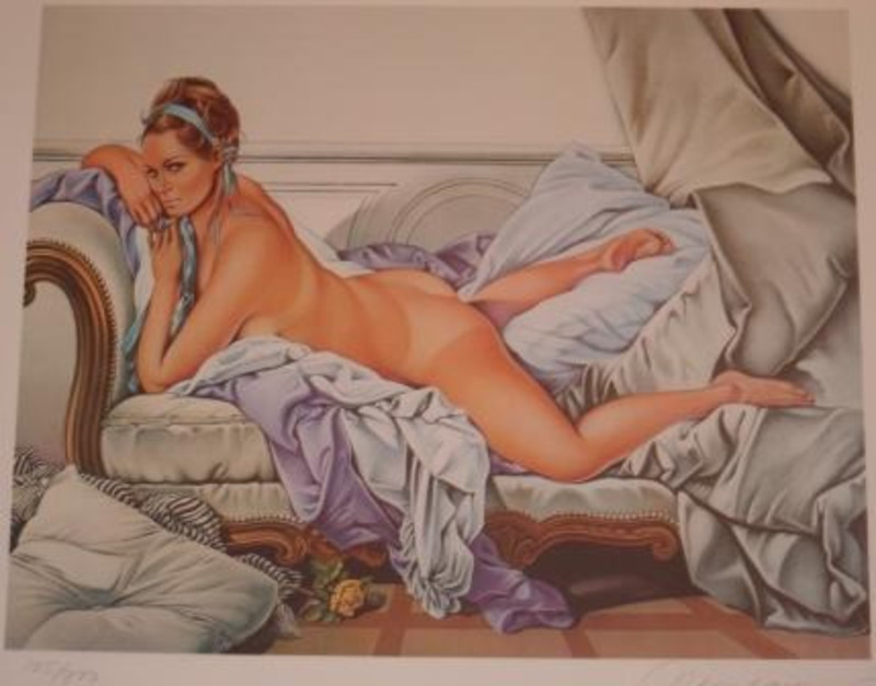 Collotype print showing a nude woman reclining on a divan covered by cloth and pillows. Stored in archival portfolio.