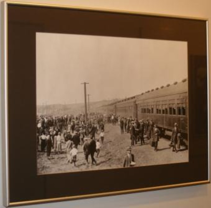 Black and white photograph showing passengers unloading from a train.