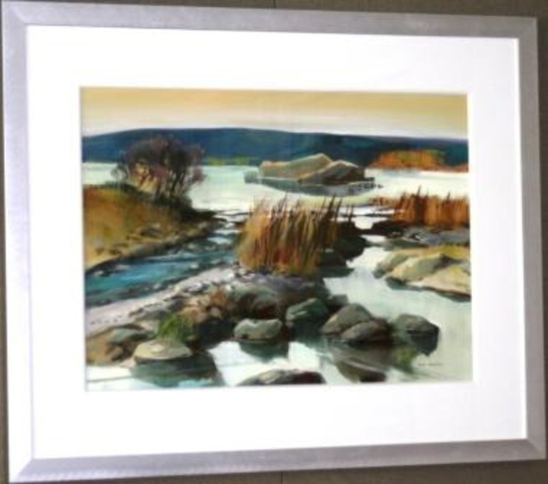 Painting of rocks and brush on the shore of a lake. The painting is signed by the artist and displayed using a white matte with a silver frame.