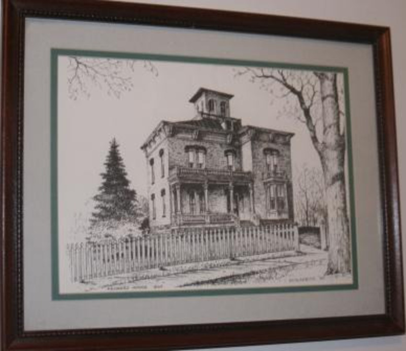 Ink drawing of a two story house with a picket fence, sidewalk, and several trees. Framed using green mattes.