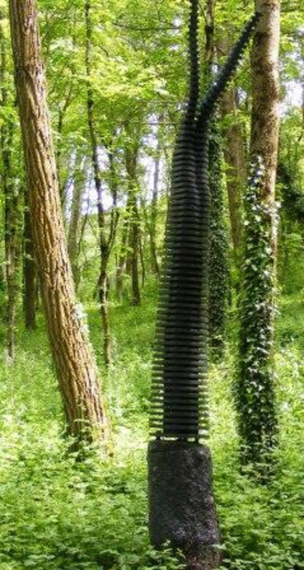 Sculpture resembling a living tree made from black painted plywood rising from a tree stump