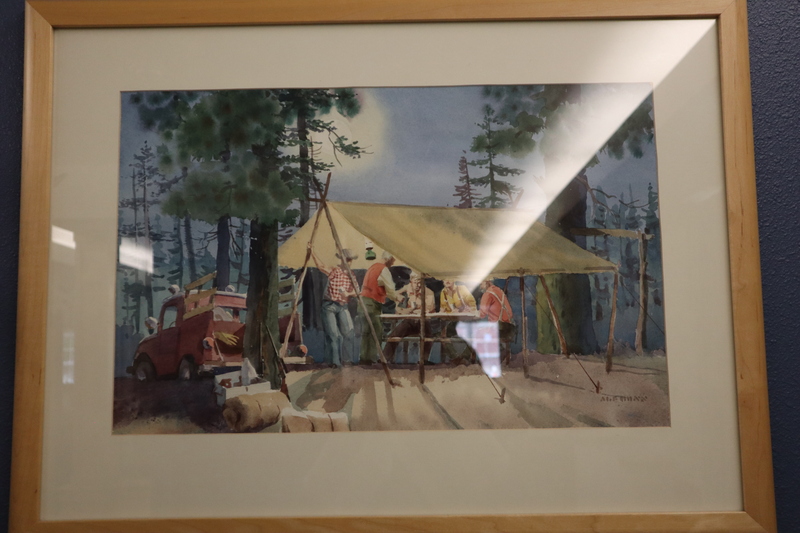 Painting of people gathered around a table beneath a shelter erected between two trees.