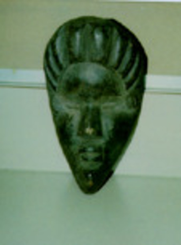 Carved wooden mask wood that has been stained black with no eyes and a solid back.