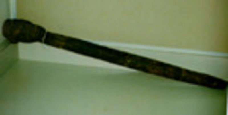 Wooden scepter with a carved head at the top.