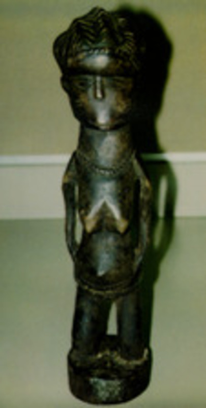 Carved wooden female figurine with beads around the waist.