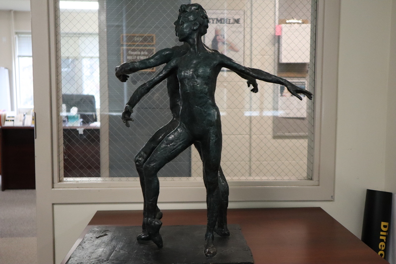 Bronze sculpture of two figures dancing ballet together back-to-back.
