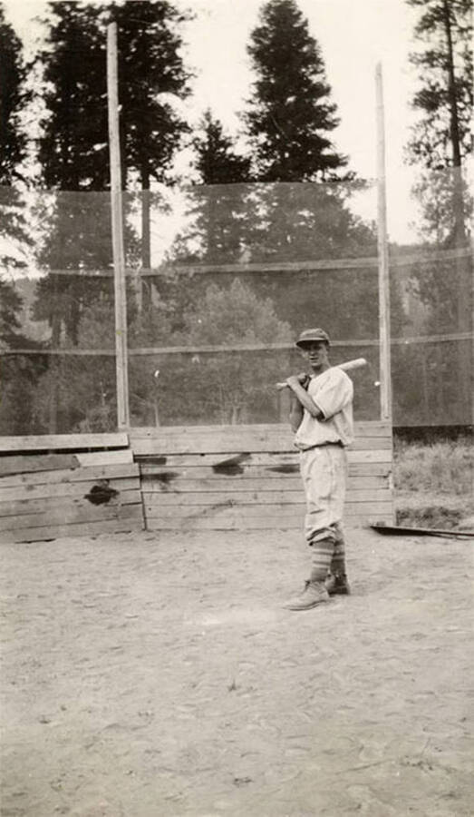 A CCC man posing with a bat over home plate.