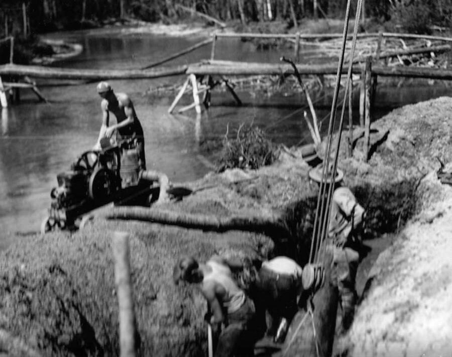 Several CCC men working on a bridge foundation near Redfish Lake in the Sawtooth National Forest, Idaho. Back of photo says: 'Bridge foundation work near Redfish Lake, Sawtooth National Forest, Idaho. Taken by K.D. Swan 1933.'