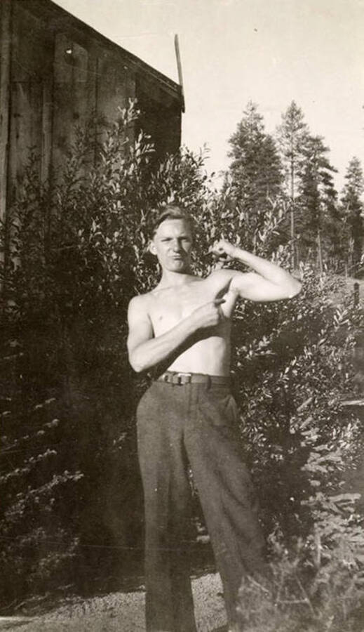 Photo of a CCC man posing for a photo and pointing at his bicep. Writing below the photo reads: 'Heinson'.