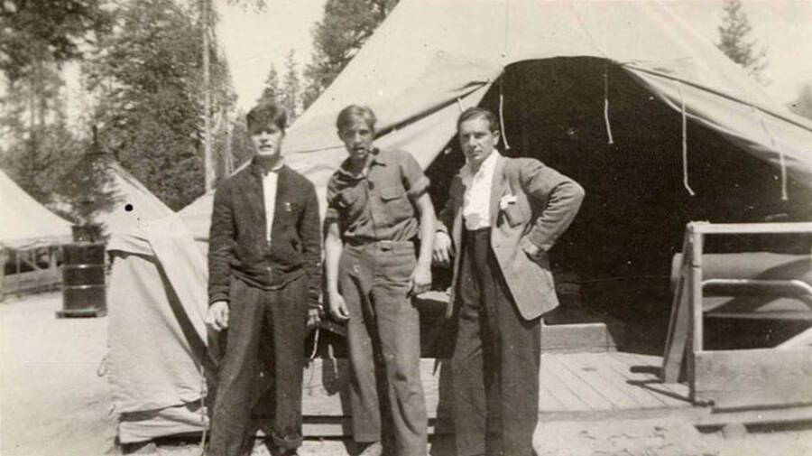 Three CCC men in front of a tent at a CCC Camp. One man had a pipe in his mouth. Writing under the photo reads: 'at warm lake'.