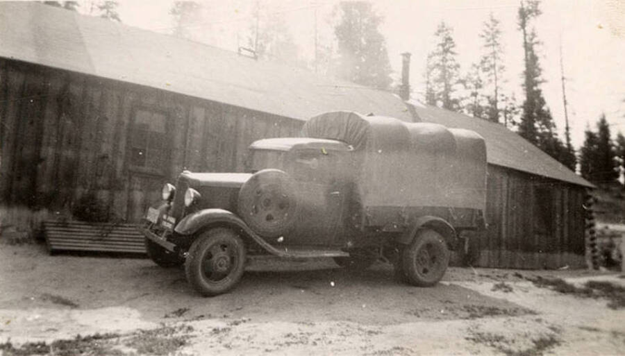 Photo of a truck in front of a building at a CCC Camp.