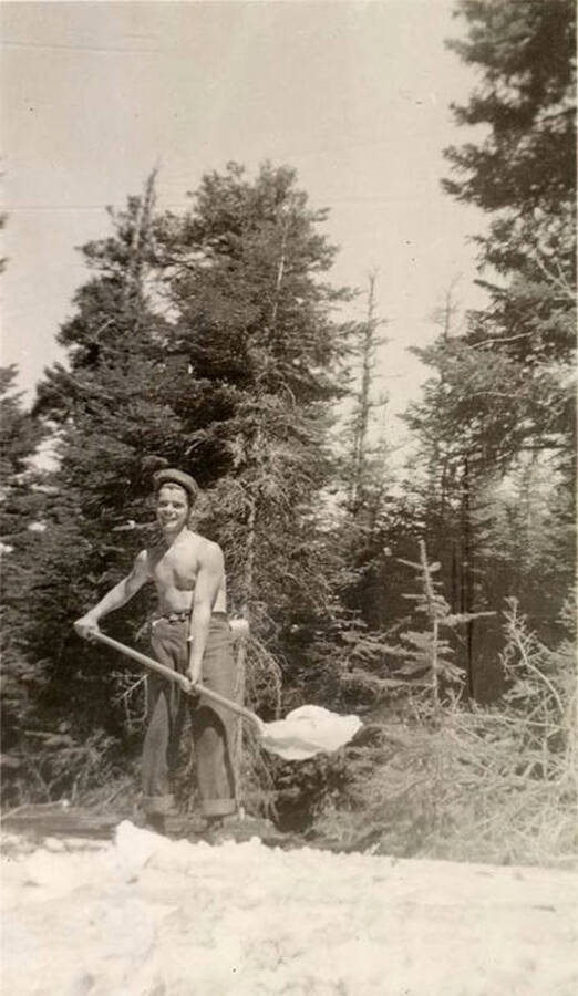A shirtless CCC man with a shovel. Maybe shoveling snow? Writing under the photo reads: 'McMann'.