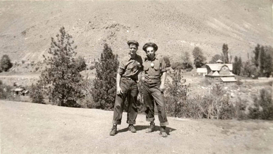 Two CCC men standing in the foreground, in front of a large house in the background. Writing under the photo reads: 'Two 'rookies''.