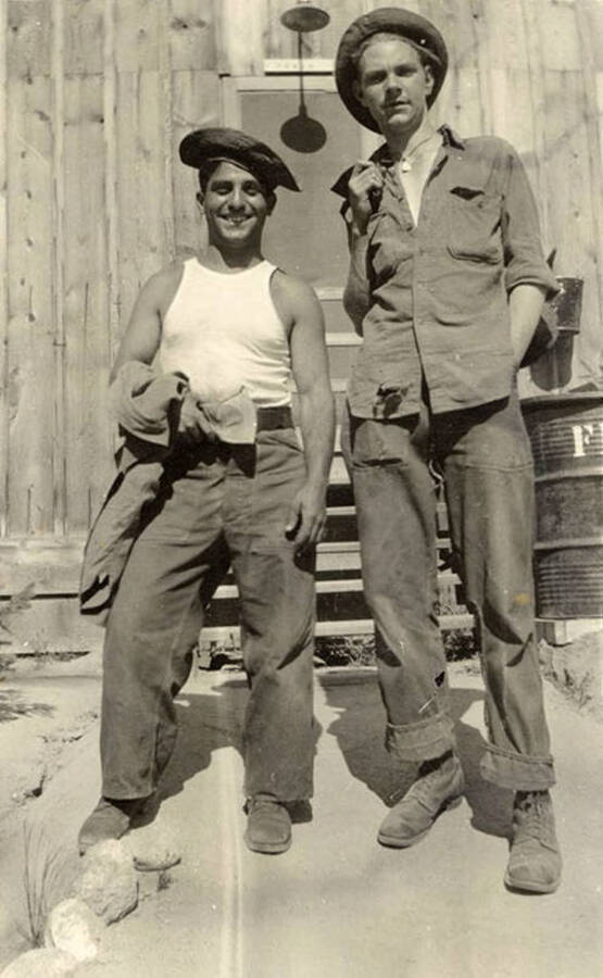 Two CCC men posing in front of a barrack at CCC Camp F-168. Writing under the photo reads: 'Mosca and Myself'.