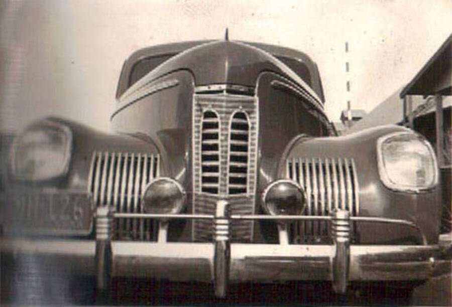Photo of the front of a CCC car. Writing on the album page reads: 'Lewiston, Idaho 1938 CCC Camp'. Writing under the photo reads: 'camp'.