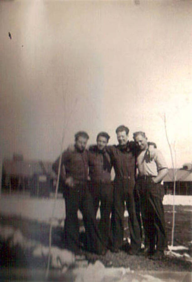 Photo of four CCC men posing in a snowy CCC camp.
