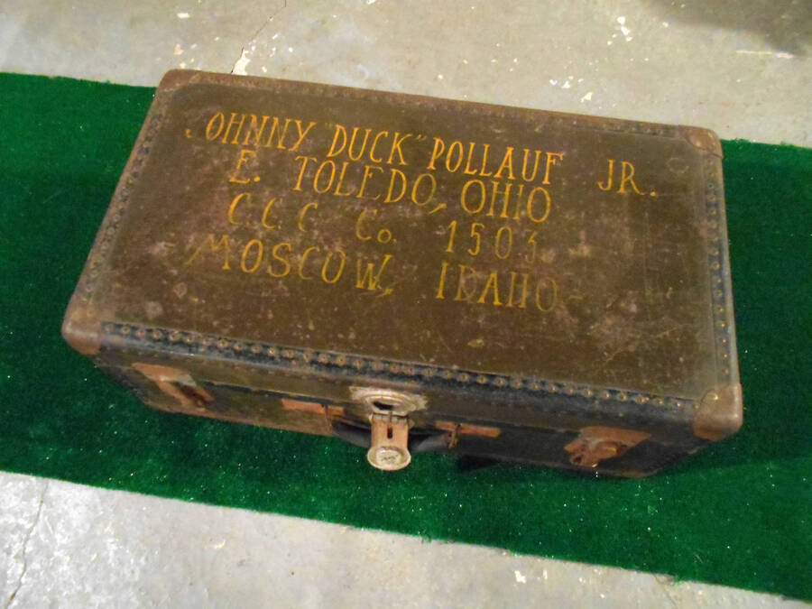 A travelling trunk that belonged to Johnny 'Duck' Pollauf. The writing on the trunk reads: 'Johnny 'Duck' Pollauf Jr. E. Toledo, Ohio CCC Co. 1503 Moscow, Idaho'.