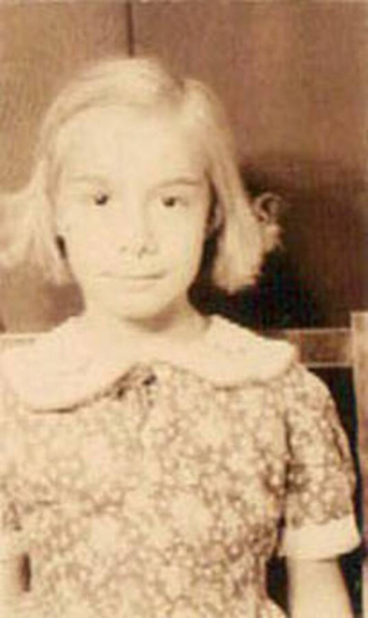 School photo of a young girl. Writing under the photo reads: '1938-39' Label on the album page reads: 'CCC Camp 1938-1939 Idaho'.
