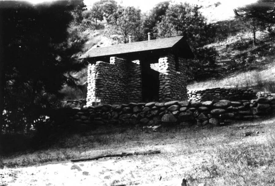 Stone outhouse built by CCC. Surrounded by a stone wall.