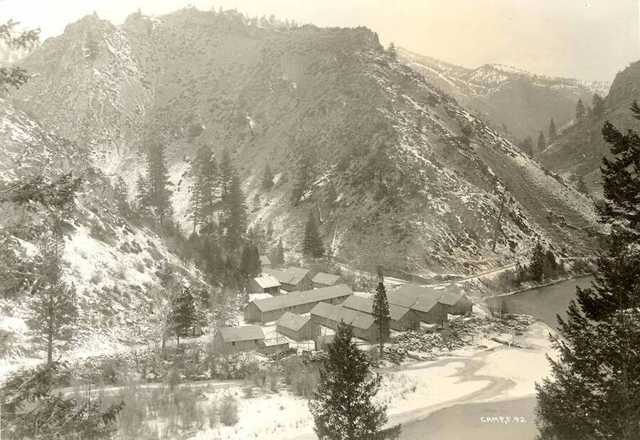 Overview of Spring Creek CCC Camp and surrounding river and mountains during winter.