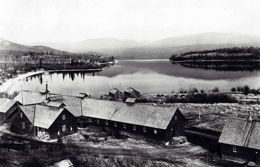 A view of Camp Kalispell Bay and the camp itself F-142, Priest Lake, Idaho. Back of photo reads: 'CCC Kalispell Bay'.