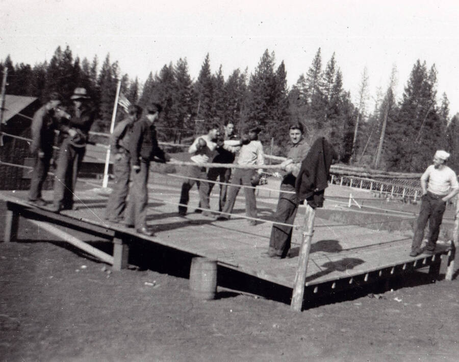 A group of men pose in the Camp Kalispell Bay boxing ring, F-142 at Priest Lake, Idaho.