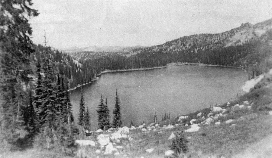 Box lake sits in a crater in the middle of the woods. Writing beneath the photo reads: '1850.0048. Box Lake, Camp French Creek, 1938'.