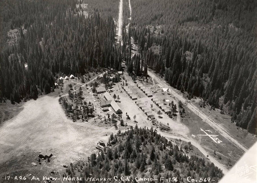 Aerial view of Horse Heaven CCC Camp. On the right side of the photo is a geoglyph or 'hillside letters' displaying F-156. Writing on the photo reads: '17-226 Air view Horse Heaven CCC Camp F-156 Company 569 Leo's Studio'.