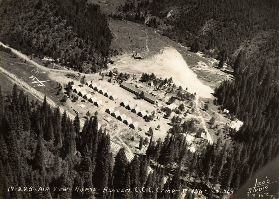 Aerial view of Horse Heaven CCC Camp. On the left side of the photo is a geoglyph or 'hillside letters' displaying F-156. Writing on the photo reads: '17-225 Air view Horse Heaven CCC Camp F-156 Company 569 Leo's Studio'.