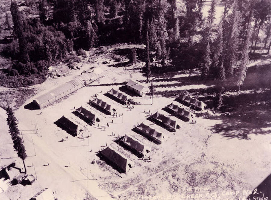 Aerial view of Big Creek #2 CCC Camp. Writing on the photo reads: 'Air View Big Creek CCC Camp Number 2 by Leo's Studio'. Back of photo reads: 'Big Creek #2 F-132 Coeur d'Alene National Forest'.