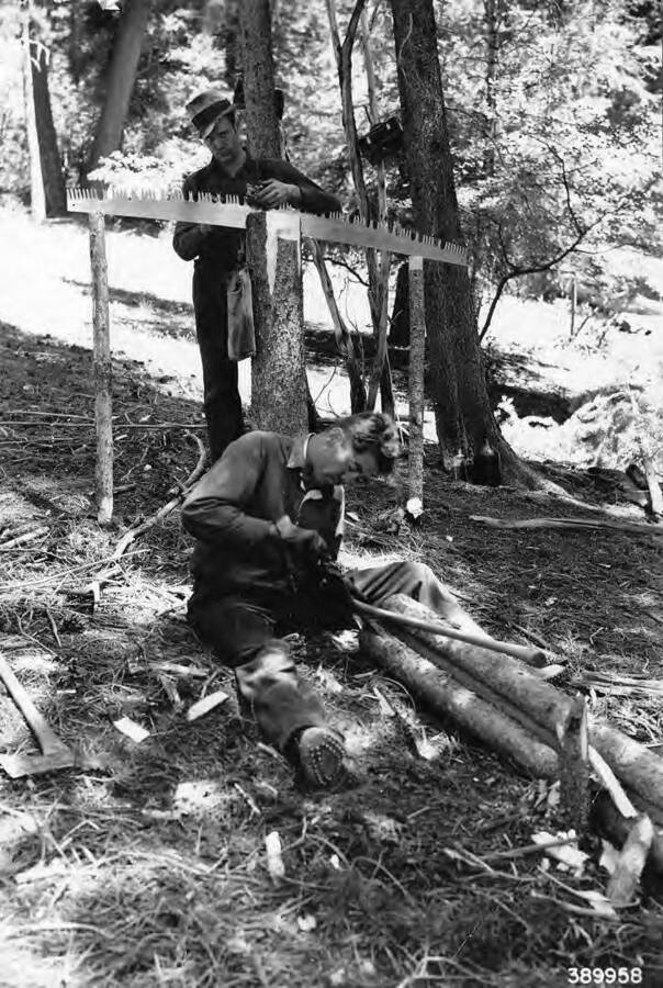 Roadside cleanup by CCC men from Camp F-78, near Pine, Idaho in the Boise National Forest. The caption reads 'Tree cutters sharpening tools in Blue Point Creek.'