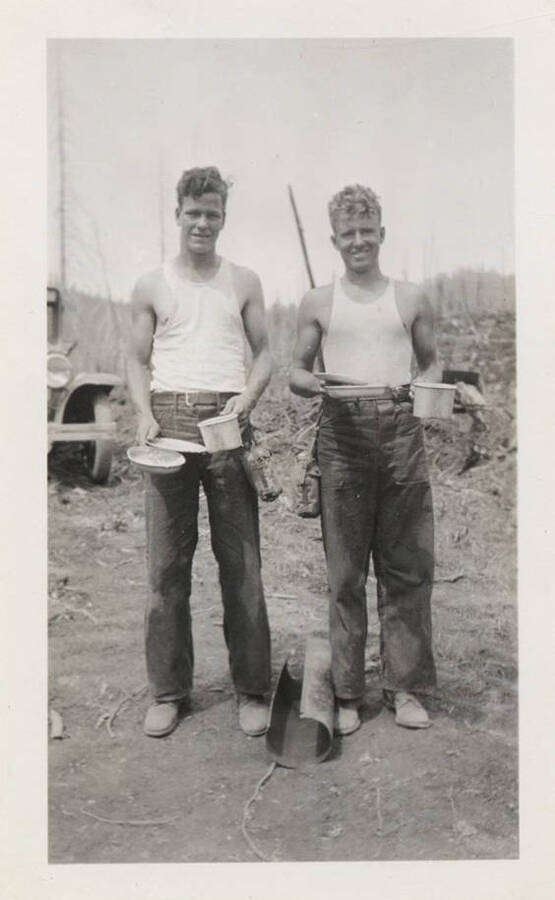Two enrollees with mess kits. The back of the photograph reads: 'CCC 'diner'!' The men can be seen holding bowls and plates.