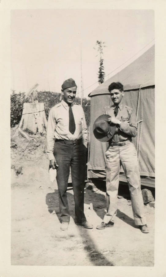 Captain B.B. Penalta and Lieutenant W.C. Mansfield stand in uniform outside of a tent in a CCC camp.