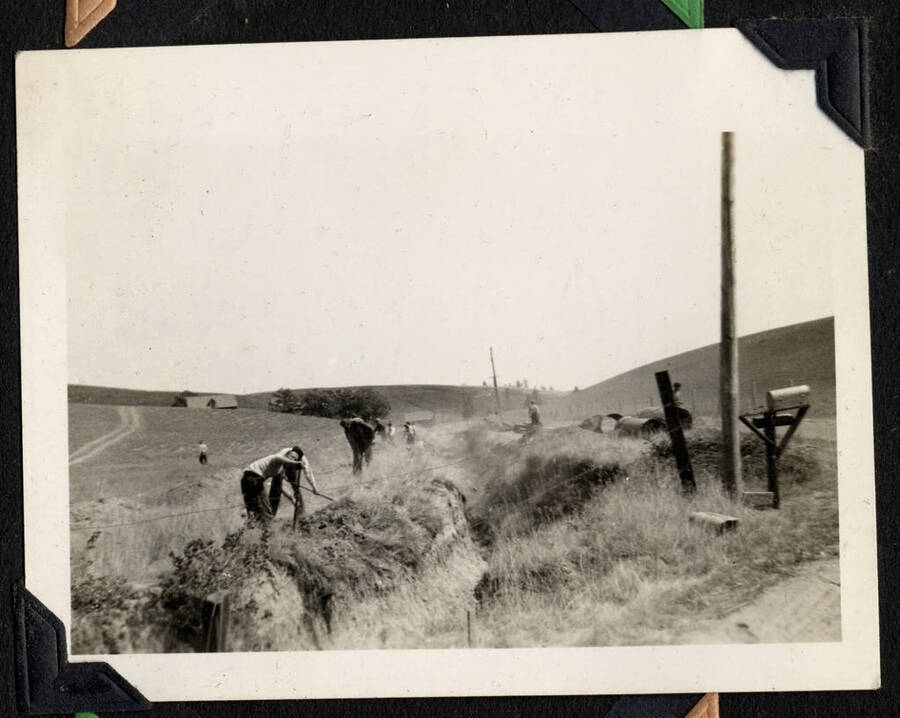 Crew working in the corner of a field among rolling hills. SCS-1, C-1503. From the Paul Saft photographic album, SCS-1, C-1503, 1938-39, depicting camp life, taken mostly in the Moscow, Lewiston, Robinson Lake areas.