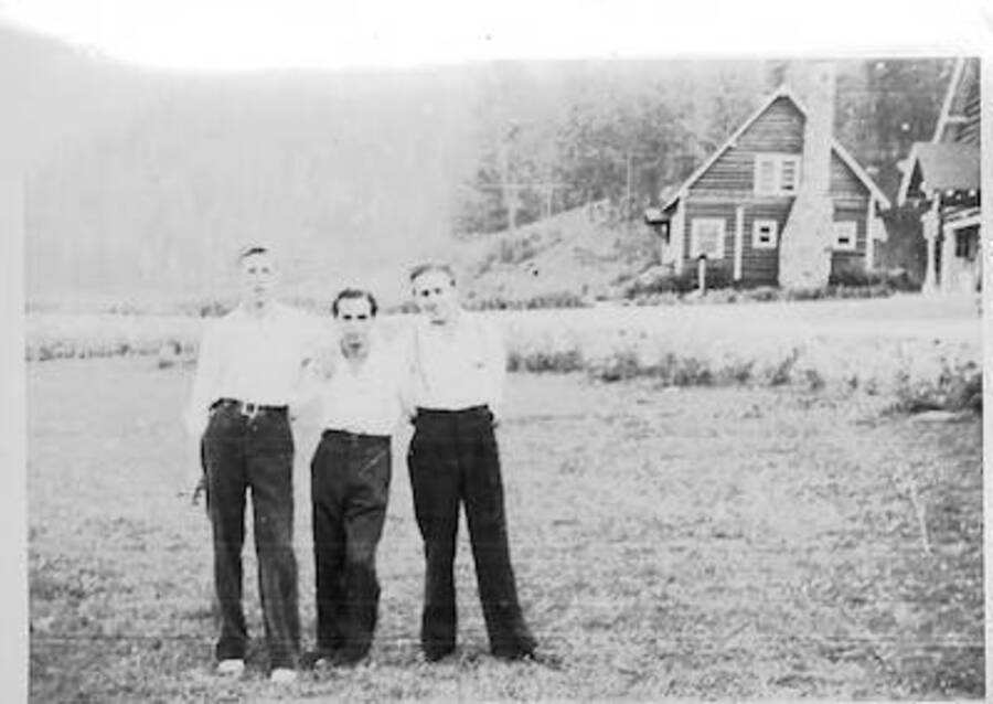 Three enrollees with administrative buildings in background. Camp Smith Ferry, 1939. Caption: 'the team'