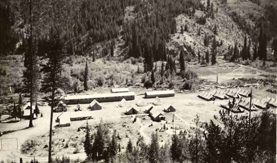 Overview of Magee CCC Camp. Note what could presumably be a baseball field on the right side of the photo behind the tent barracks. Back of photo reads: 'CCC Camp Magee 1933'.