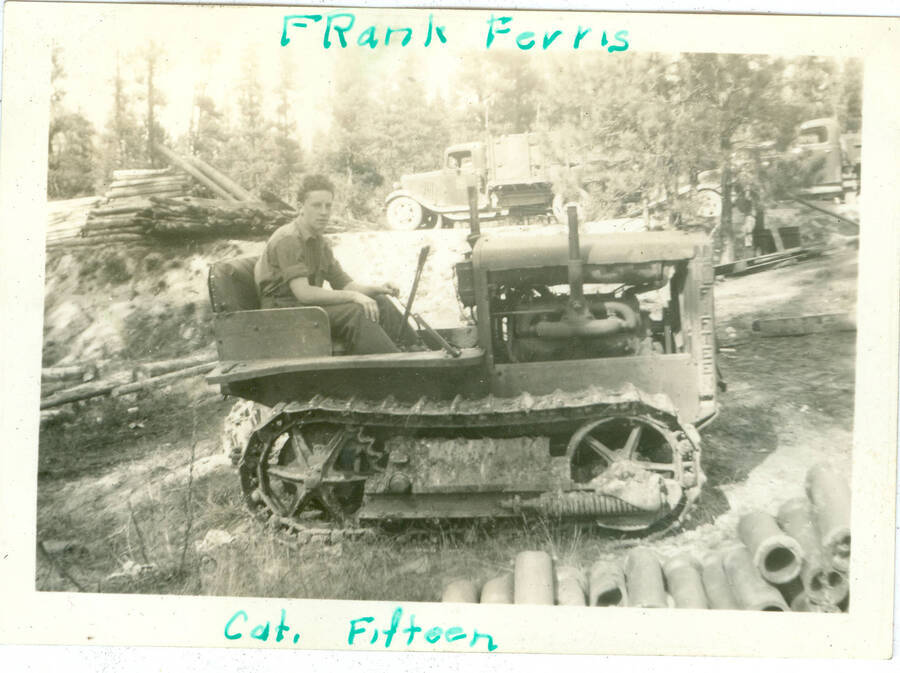 Picture of man on small tractor with handwritten caption: 'Frank Ferris' 'Cat. Fifteen'.  This is likely to be located near Camp Creek, South Fork of the Salmon River, which built Krassel Ranger Station.
