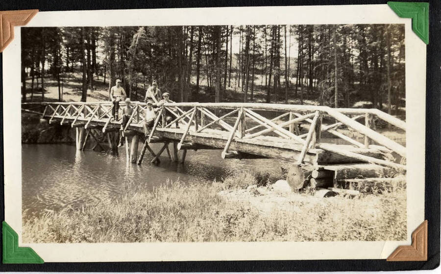 Five men posing on log and post bridge over river. SCS-01, C-1503. From the Paul Saft photographic album, SCS-1, C-1503, 1938-39, depicting camp life, taken mostly in the Moscow, Lewiston, Robinson Lake areas.