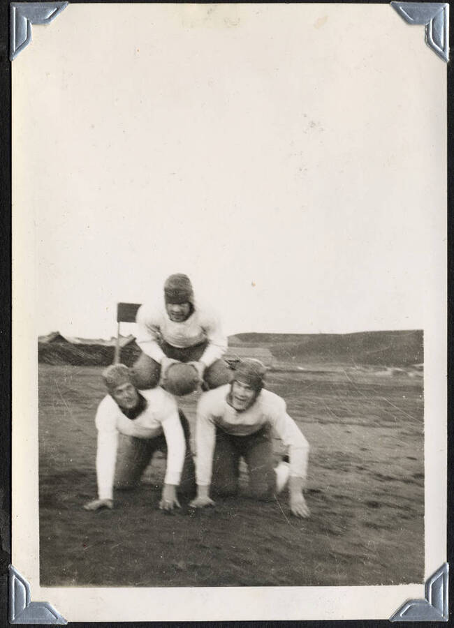 Three men in football gear, SCS-01, C-1503. From the Paul Saft photographic album, SCS-1, C-1503, 1938-39, depicting camp life, taken mostly in the Moscow, Lewiston, Robinson Lake areas.
